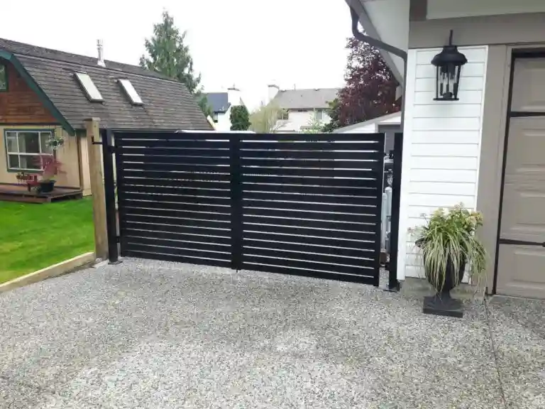A modern black metal horizontal slat gate, complemented by elegant Aluminum Railings Langley, blocks