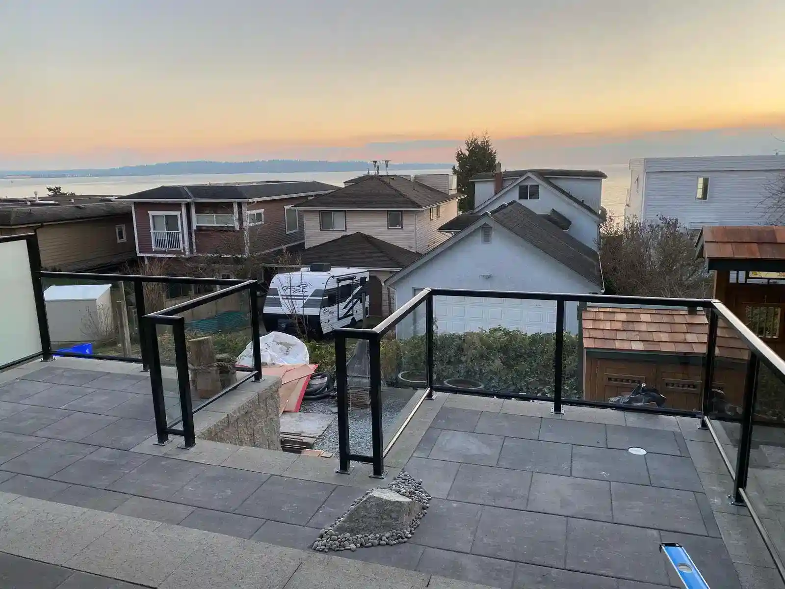 Residential patio with customizable aluminum railings overlooks neighboring houses and water in the