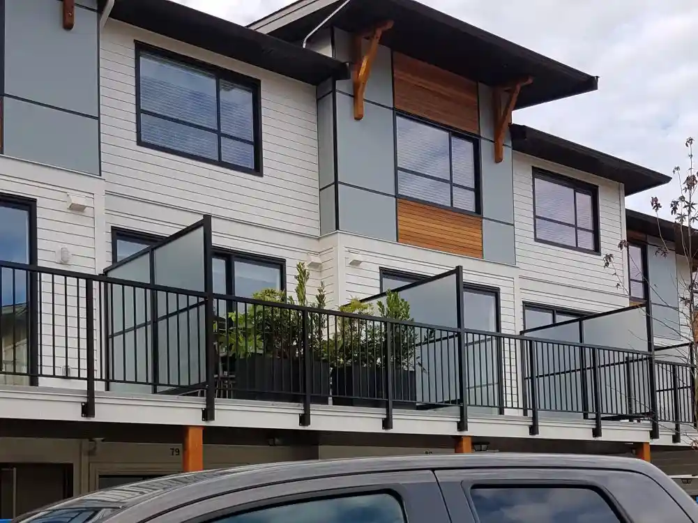 Modern two-story apartment building with large windows, a balcony featuring LDH Aluminum Ltd.