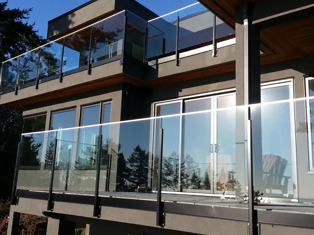Modern two-story house featuring large glass balcony railings by LDH Aluminum Ltd. – Railings &amp