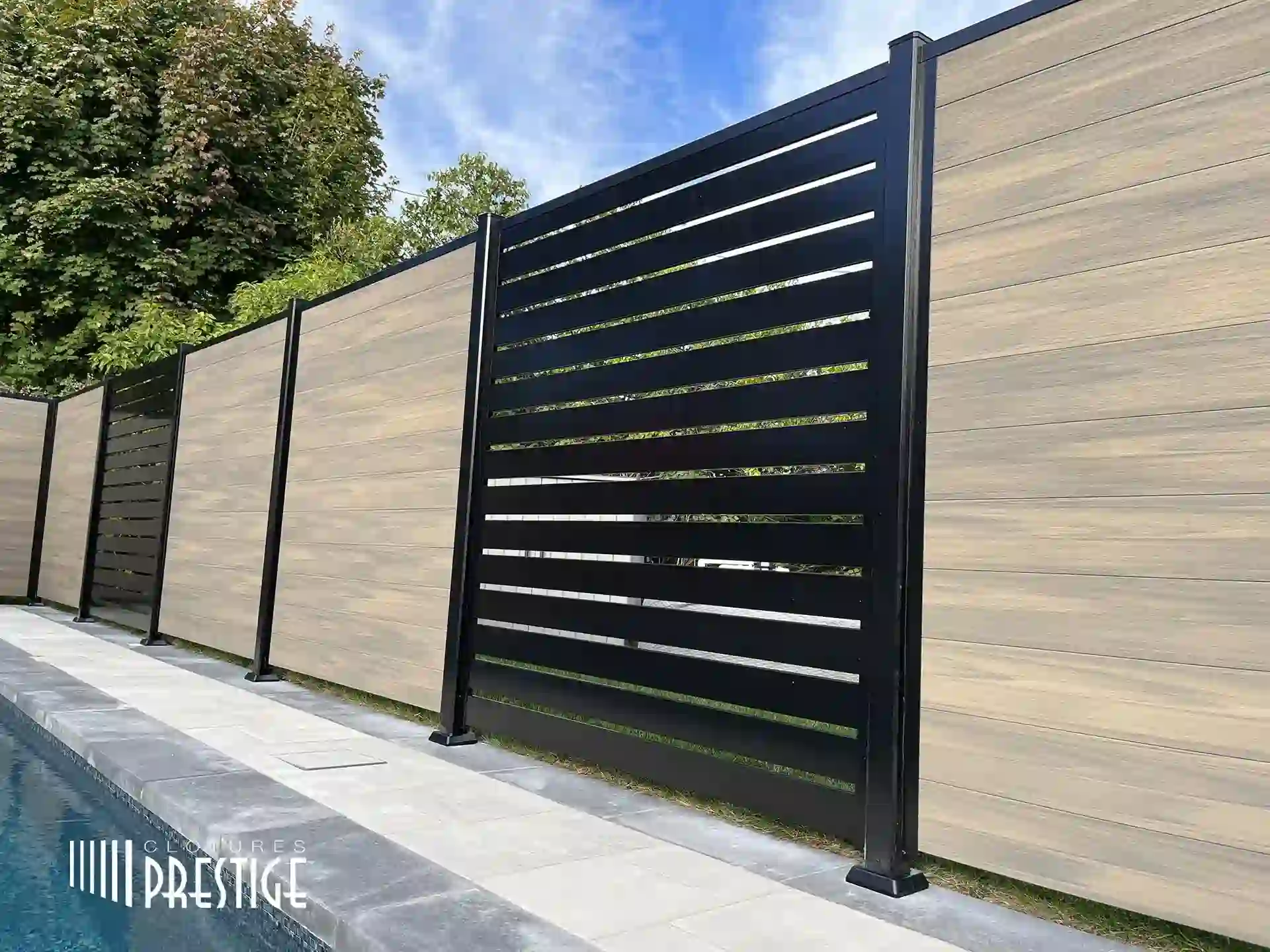 Modern composite and aluminum fencing with horizontal wood-look and black metal slats stands beside